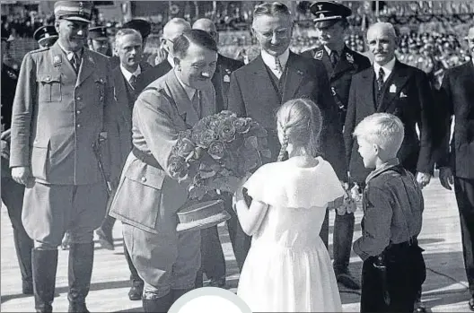 ?? ULLSTEIN BILD / GETTY ?? Flores y niños. Hitler recibe un ramo de manos
infantiles al poner en 1934 la primera piedra del Reichsbank en Berlín