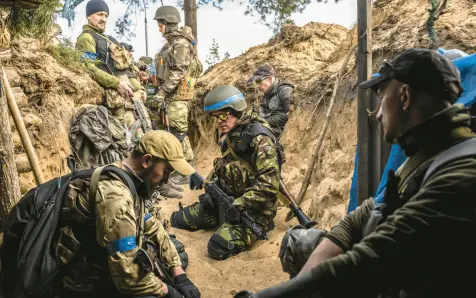  ?? DANIEL BEREHULAK/THE NEW YORK TIMES ?? Fighters in Ukraine’s Odin Unit, made up of Ukrainians and foreign volunteers including Americans, are seen March 29 in Irpin, Ukraine. Some would-be fighters are there looking to fill their own personal goals.