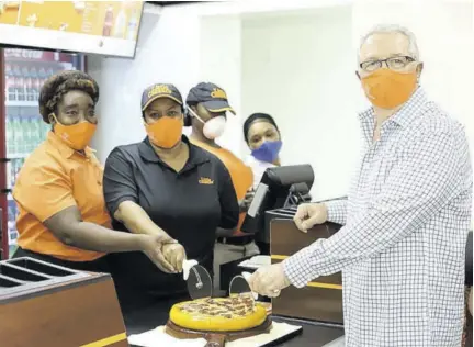  ??  ?? Restaurant Associates Limited Executive Director Frank Ventura (right) is joined by Operations Manager Kerry Ann Griffiths (left) and Restaurant Manager Maria Solomon in cutting the welcome pizza, at the opening of the new Little Caesars pizza restaurant in Mandeville last Thursday.