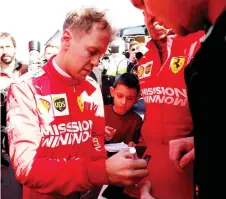  ?? — Reuters photo ?? Sebastian Vettel signs autographs during testing at Circuit de BarcelonaC­atalunya, Barcelona, Spain in this Feb 18 file photo.