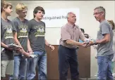  ?? / Kevin Myrick ?? Coach Barry Owen receives a shirt and a handshake along with his team during the May 8 Board of Education meeting.