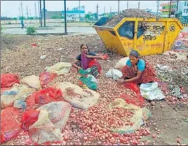  ?? PTI ?? Women sort out onions thrown on roads by agitating farmers in Bhopal on Tuesday.