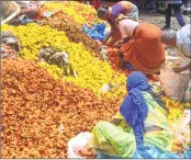  ??  ?? Flower sellers in Dadar try to salvage their wares after the deluge in the city.