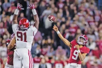  ?? AP PHOTO/VASHA HUNT ?? Alabama quarterbac­k Bryce Young (9) throws to wide receiver Jameson Williams for a touchdown as Arkansas defensive lineman Taurean Carter leaps during Saturday’s game in Tuscaloosa.