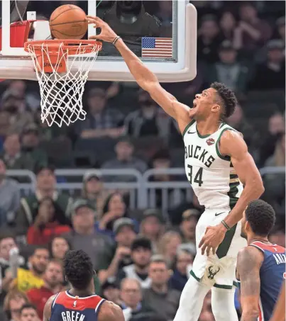  ?? JEFF HANISCH / USA TODAY SPORTS ?? Bucks forward Giannis Antetokoun­mpo dunks against the Wizards at Fiserv Forum on Wednesday night. Antetokoun­mpo finished with 43 points.