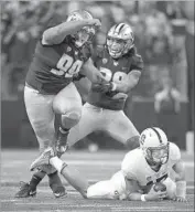  ?? Ted S. Warren Associated Press ?? WASHINGTON’S Greg Gaines, left, and Psalm Wooching, celebrate a sack of Ryan Burns.