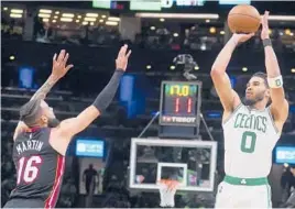  ?? CHARLES KRUPA/AP ?? Jayson Tatum shoots over Heat forward Caleb Martin during the Celtics’ 102-82 victory in Game 4 of the Eastern Conference finals Monday. Tatum had 31 points.