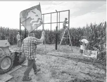  ?? NATI HARNIK/THE ASSOCIATED PRESS ?? Tom Genung of the organizati­on Bold Nebraska prepares to pitch a flag of the Cowboy Indian Alliance at the proposed path of the Keystone XL pipeline in Silver Creek, Neb., last month. Opponents of the project are vowing to block its constructi­on.