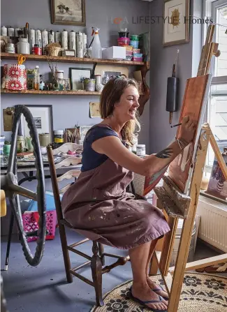  ??  ?? TOP Jo at work in her studio, which is at the top of the house FACING PAGE In the living room, Jo’s colourful collection of vases and jugs, displayed on custom- made shelves, stands out against the calming backdrop of the blue-grey walls painted in Farrow &amp; Ball’s ‘Inchyra Blue’