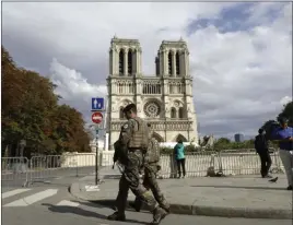  ?? Lewis Joly The Associated Press ?? French soldiers clear the area around Notre Dame Cathedral on Monday in Paris. Authoritie­s are clearing the area ahead of decontamin­ation and cleanup work.