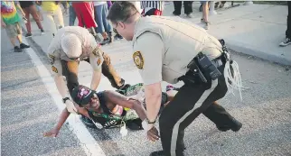  ?? SCOTT OLSON/GETTY IMAGES FILES
  ?? A demonstrat­or is arrested while protesting the killing of teenager Michael Brown last August in Ferguson, Mo.