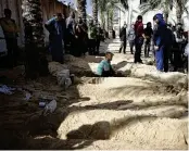  ?? MOHAMMED DAHMAN / ASSOCIATED PRESS ?? Palestinia­ns dig graves to bury their relatives who were killed in the Israeli bombardmen­t of the Gaza Strip, at the Nasser hospital in Khan Younis, Southern Gaza Strip, Monday.