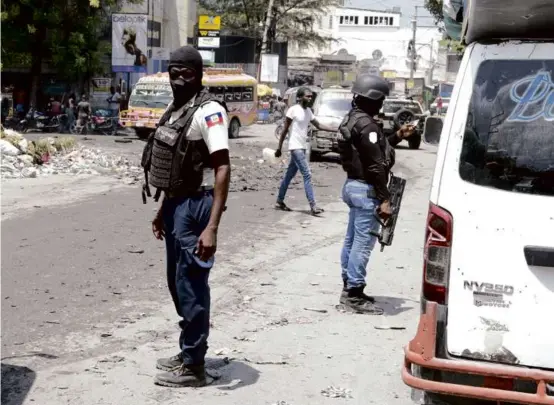  ?? ODELYN JOSEPH/ASSOCIATED PRESS ?? National Police patrol an intersecti­on amid gang violence in Port-au-Prince, Haiti, on Monday.