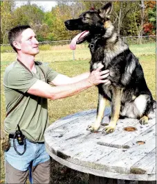  ?? Photo by Mike Eckels ?? Mike Wood gives a command to “stay” to Low Key during a working session at Ozark Canine Academy near Decatur.