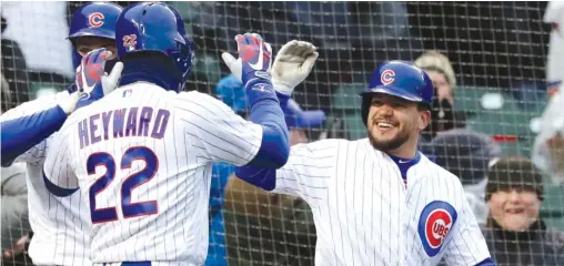  ??  ?? NAMY. HUH/ AP Kyle Schwarber ( right) celebrates with teammate Jason Heyward after scoring on a wild throw during the Cubs’ nine- run eighth inning Saturday.