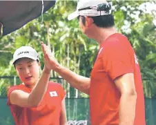  ?? ?? Yui celebrates a point with Japan captain Nakayama Yoshinori during her match against Chotirin Kaewka of Thailand in the first singles.