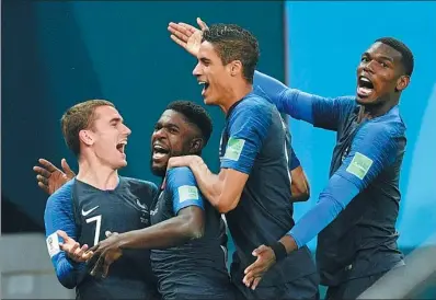  ?? MARTIN MEISSNER / AP ?? France’s Samuel Umtiti (second from left) is mobbed by teammates (from left) Antoine Griezmann, Raphael Varane and Paul Pogba after scoring the only goal of Tuesday’s World Cup semifinal victory over Belgium in St. Petersburg Stadium.