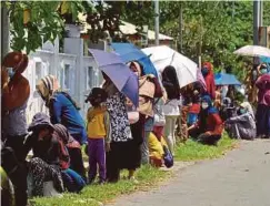  ??  ?? ORANG ramai beratur, memakai pelitup muka dan melakukan imbasan kod QR ketika hadir mengambil barangan keperluan harian yang diperlukan.