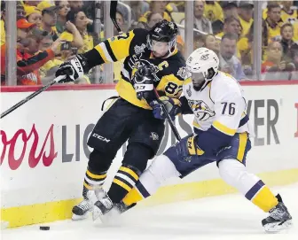  ??  ?? Penguins centre Sidney Crosby and Predators defenceman P.K. Subban battle for the puck during the second period of Game 1 on Monday in Pittsburgh.