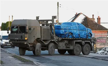  ??  ?? Under scrutiny: A vehicle wrapped in blue tarpaulin being removed from Larkhill Road in Durrington, 16km north of Salisbury. The vehicle is suspected to be linked to the spy poisoning case. — AP