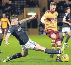  ??  ?? Kerr Waddell puts in a tackle on Motherwell’s man-ofthe-moment Louis Moult.