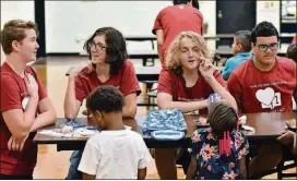  ?? PHOTOS BY HYOSUB SHIN / HSHIN@AJC.COM ?? Band members from Hillgrove High school interact with students at Compton Elementary School in Powder Springs on Sept. 20. The band also distribute­d meals for the Compton students to enjoy during fall break.