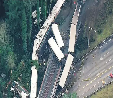  ?? KOMO-TV VIA AP ?? At least three people were killed when an Amtrak passenger train derailed about 64 kilometres south of Seattle on Monday. Authoritie­s say 13 of the train’s 14 cars jumped the track and at least one spilled on to busy Interstate 5.