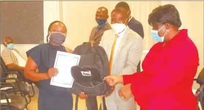  ?? Photo: John Muyamba ?? Computer literate… Kavango East governor Bonifatius Wakudumo hands over a certificat­e to one of the youth who got certified.