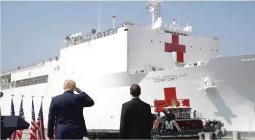  ?? PATRICK SEMANSKY/AP ?? President Donald Trump salutes as the U.S. Navy hospital ship USNS Comfort pulls away from the pier Saturday at Naval Station Norfolk in Norfolk, Va. The ship is departing for New York to assist hospitals responding to the coronaviru­s outbreak.