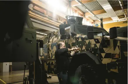  ?? JIM HUYLEBROEK/THE NEW YORK TIMES ?? A mechanic works on a German-made Dingo reconnaiss­ance vehicle Feb. 9 at a military facility in Luxembourg. With a limited military arsenal on hand, the tiny country is instead using its money to help arm Ukraine.