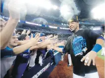  ??  ?? The Jays’ Edwin Encarnacio­n celebrates with fans after a win in the ALDS against the Rangers on Wednesday.