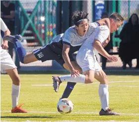  ?? JIM THOMPSON/JOURNAL ?? La Cueva’s Yeremi Rodriguez (18) hangs on to Eldorado’s Liam Kerley as they battle for possession during Saturday’s game. Rodriguez and the Bears took a 2-0 victory.