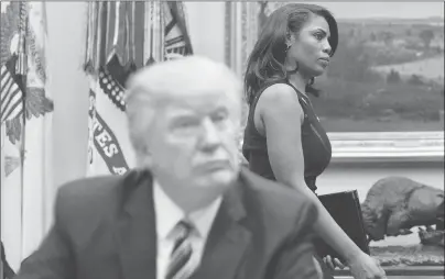  ?? AP PHOTO ?? White House Director of communicat­ions for the Office of Public Liaison Omarosa Manigault, right, walks past President Donald Trump on March 12, 2017, during a meeting on health care in the Roosevelt Room of the White House.