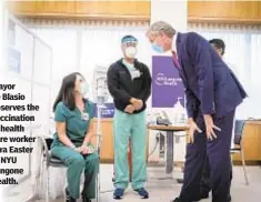  ??  ?? Mayor de Blasio observes the vaccinatio­n of health care worker Tara Easter at NYU Langone Health.