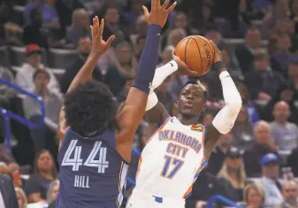  ?? Sue Ogrocki / Associated Press ?? Oklahoma City guard Dennis Schroder shoots over Memphis forward Solomon Hill in the first half; Memphis was up 6859 at halftime. The Grizzlies led 8965 before the Thunder rallied.