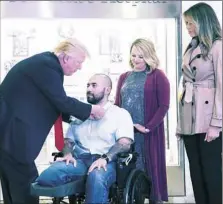  ?? Shawn Thew/Getty Images ?? President Donald Trump, with first lady Melania Trump, awards the Purple Heart to Sgt. 1st Class Alvaro Barrientos, with his wife Tammy Barrientos, during a visit to Walter Reed National Military Medical Center Saturday in Bethesda, Md. Sgt. Barrientos...