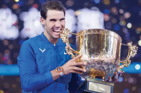  ??  ?? Rafael Nadal of Spain with the trophy after winning the men’s singles final match against Nick Kyrgios of Australia at the China Open tennis tournament in Beijing on Sunday. (AFP)