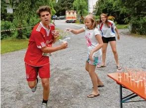  ?? Foto: Reinhold Radloff ?? Viel trinken und weniger verschütte­n, das ist beim Landkreisl­auf in Thierhaupt­en aufgrund der hohen Tem peraturen am Sonntag anzuraten. Für alle Notfälle stehen aber Krankenwag­en bereit.