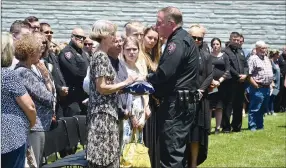  ?? TIMES photograph­s by Annette Beard ?? Dalene Hart, center left, received the flag that draped her son’s casket from Pea Ridge Police Chief Lynn Hahn, during the outside memorial that followed the funeral service for slain Pea Ridge Police Officer Kevin Apple Friday, July 2, at Cross Church.