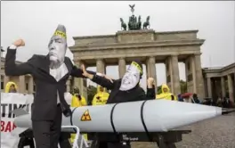  ?? OMER MESSINGER, GETTY IMAGES ?? Internatio­nal Campaign to Abolish Nuclear Weapons activists wearing masks to look like U.S. President Donald Trump and North Korean leader Kim Jong Un protest in Germany last month.