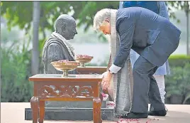  ?? REUTERS ?? British Prime Minister Boris Johnson places rose petals on the statue of Mahatma Gandhi during his visit to the Sabarmati Ashram in Ahmedabad on Thursday.