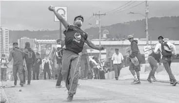  ?? Orlando Sierra / AFP / Getty Images ?? Supporters of Honduran presidenti­al rival Salvador Nasralla protested through the night outside the electoral court’s facilities, where vote counting has dragged on for four days.