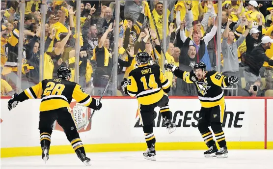  ?? JAMIE SABAU/GETTY IMAGES ?? Pittsburgh Penguins left wing Chris Kunitz, centre, with teammates Sidney Crosby, right, and Ian Cole after scoring the game winner in the second overtime period Thursday night in Pittsburgh. The Pens will play the Nashville Predators for the Stanley...