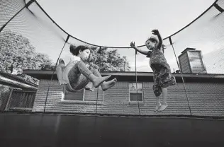  ?? Photos by Yi-Chin Lee / Staff photograph­er ?? Maya Stanton, 10, and Norah Raffle, 5, play on the trampoline after a Shabbat dinner this month. The Stantons and the Raffles are close friends and neighbors.