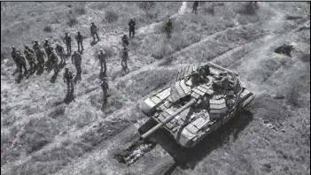  ?? Tribune News Service ?? In this aerial view, a Ukrainian Army tank drives over an infantryma­n during a training exercise on May 9, 2022, near Kryvyi Rih, Ukraine.