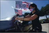  ?? LM OTERO — THE ASSOCIATED PRESS ?? Ann Grannan puts a flag on her car before a Ridin’ With Biden event Sunday in Plano, Texas.