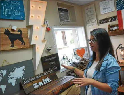  ?? PHOTOS BY JOHN BREWER — ONEIDA DAILY DISPATCH ?? Owner Kym Dirig shows off several products on display inside Kym’s Pallet Art at 127Broad St., Oneida.