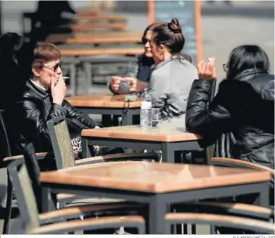  ?? ALEJANDRO GARCÍA / EFE ?? Dos mujeres fumando en una terraza de Barcelona.