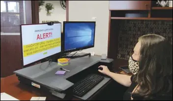  ?? JULIE DRAKE/VALLEY PRESS ?? Betsy Sanchez, Antelope Valley College’s executive director for Marketing and Public Informatio­n, looks at an emergency alert she received as part of the Great ShakeOut Earthquake drill Thursday morning.