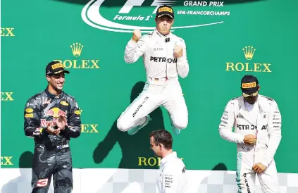  ?? Picture: Getty Images ?? JUMPING FOR JOY. Germany’s Nico Rosberg leaps in the air to celebrate his victory at the Belgium Grand Prix at Spa-Francorcha­mps flanked by second-placed Australian Daniel Ricciardo and team-mate Lewis Hamilton yesterday.